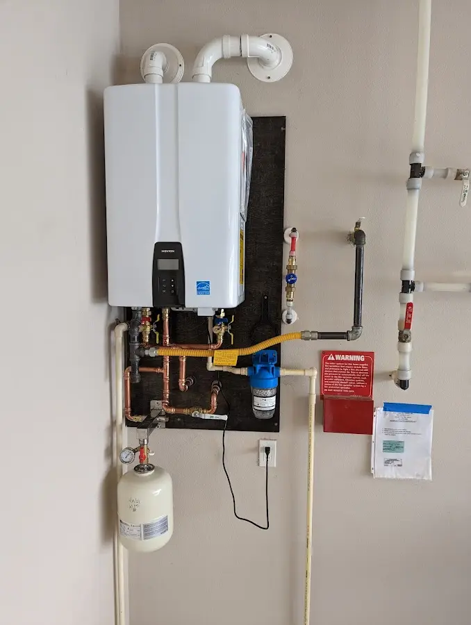 Professional plumber installing copper piping in a North Ogden home